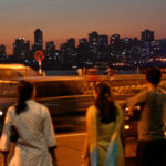 Pedestrians watch traffic in Mumbai